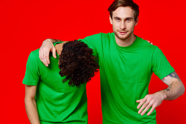 Amigos alegres em t-shirts verdes abraços comunicação positiva - Foto, Imagem
