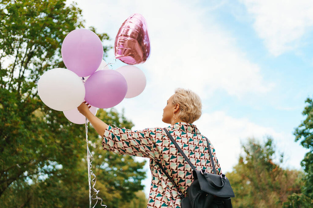 Blonde woman with pink balloons - 写真・画像