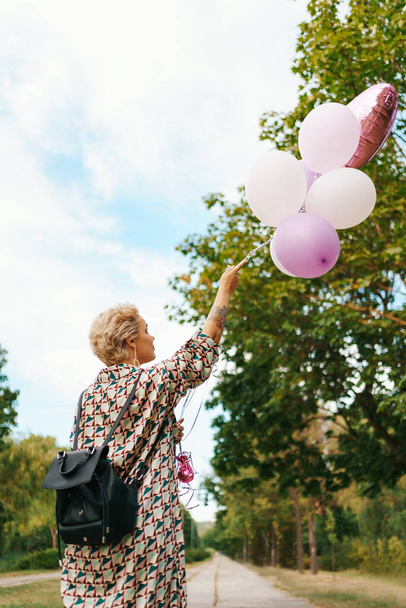Donna bionda con palloncini rosa - Foto, immagini