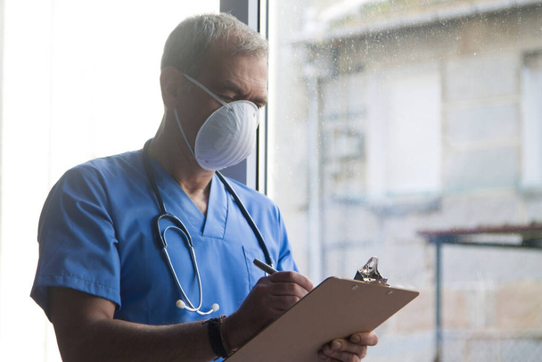 doctor with mask, stethoscope and reports, coronavirus virus concept and infections - Photo, image