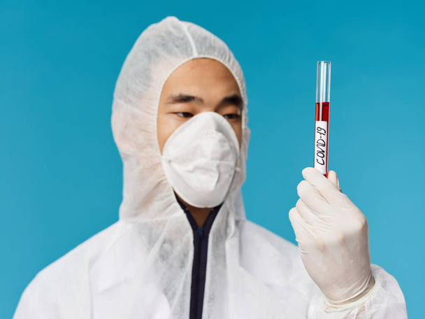 Άνδρας βοηθός εργαστηρίου διαγνωστική έρευνα αίματος μία εξέταση μπλε φόντο γκρο πλαν - Φωτογραφία, εικόνα