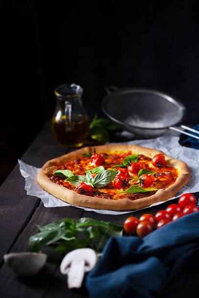 Pizza with tomatoes, mushroom and basil on a dark background, vertical - Fotoğraf, Görsel
