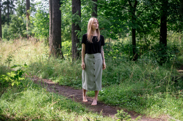 Practice of meditation and interaction with nature. Girl in green forest - Fotografie, Obrázek