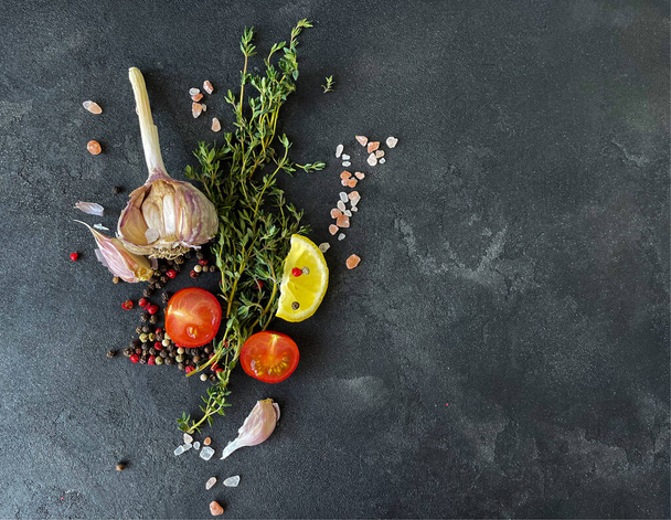valkosipuli, timjami, tomaatti, sitruuna ja mausteet mustalla betonipöydällä - Valokuva, kuva