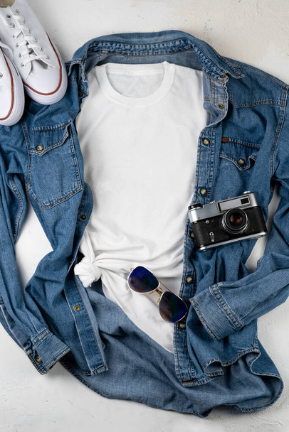 White T-shirt with place for text. Blue denim shirt, sneakers, glasses - a set of clothes for walking. T-shirt mockup for printing. Stylish kit. Copy space. - 写真・画像