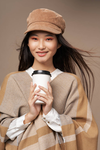 femme en chemise et veste beige chapeau tasse de boissons chaudes vêtements élégants - Photo, image