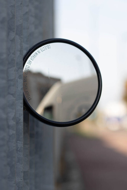 Вид круглого зеркала на металлическом заборе, Реджио Эмилия. Италия - Фото, изображение