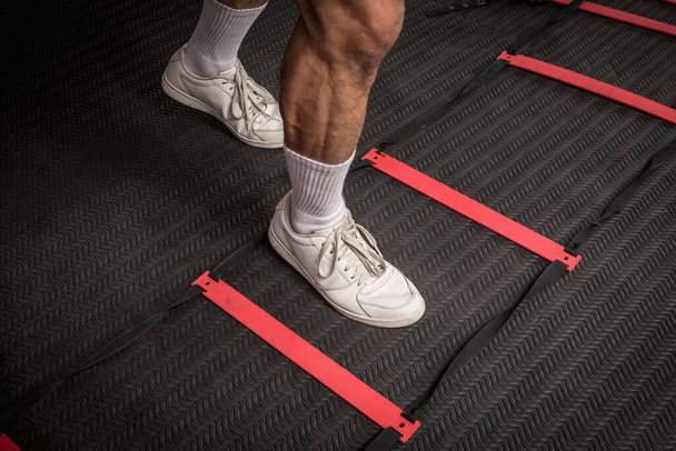 Lábmunka egy mozgékonysági létrán. Egy láb a téren belül. Fitness, kardio és intenzív sport edzés koncepció. - Fotó, kép