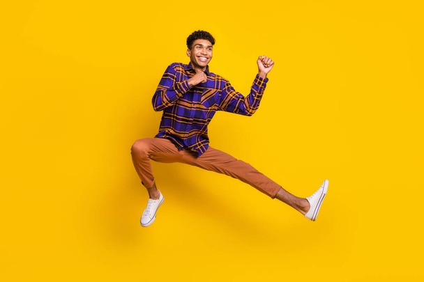 Full length body size photo of young man careless jumping playful fighting on training isolated vibrant yellow color background - Foto, Imagem