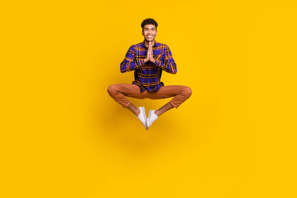 Full body portrait of carefree dark skin guy jump hands palms pleading isolated on yellow color background - Foto, imagen