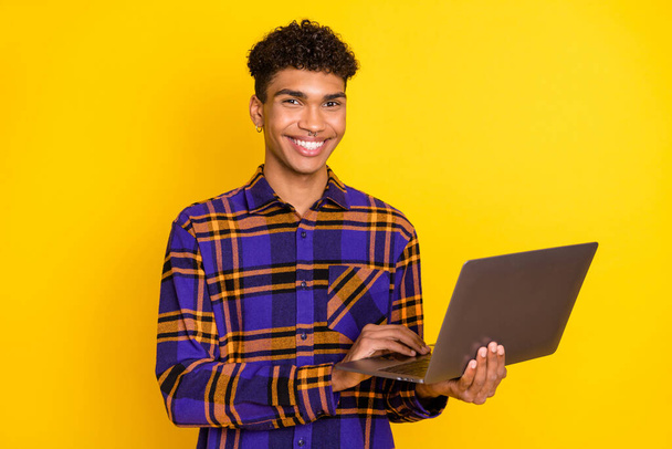 Photo portrait of young man working on computer doing project isolated vivid yellow color background - 写真・画像