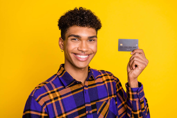 Photo of young african man happy positive smile hold credit card buy customer isolated over yellow color background - Fotó, kép