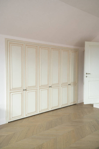 built-in wardrobe in the children's room with parquet and sloping roof - Photo, Image
