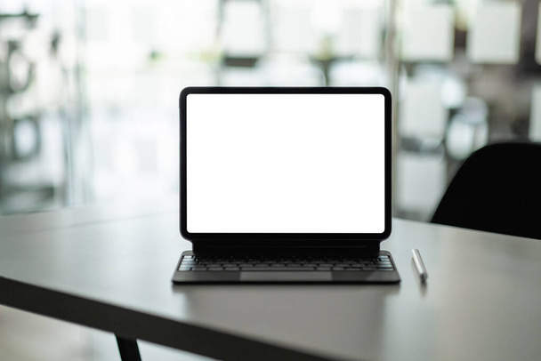 Моделирование цифрового планшета с чистым белым экраном на рабочем месте в офисе. - Фото, изображение