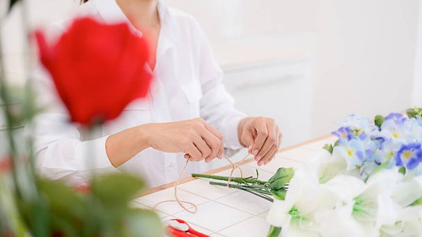 Woman hands making flower composition at florist workshop. Do it yourself concept. - Foto, Imagem