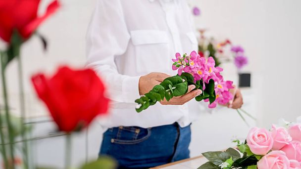 Woman hands making flower composition at florist workshop. Do it yourself concept. - Фото, зображення