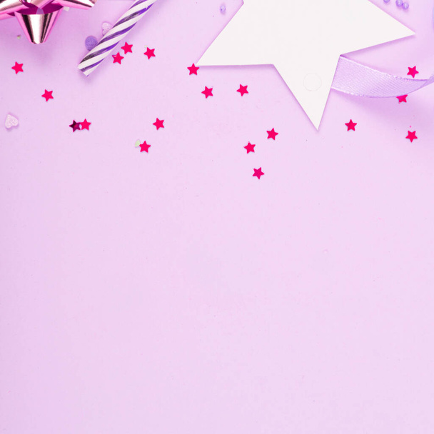 Party Holiday Hintergrund mit Schleife, Sternen, Geburtstagskerzen und Konfetti auf rosa Hintergrund. - Foto, Bild