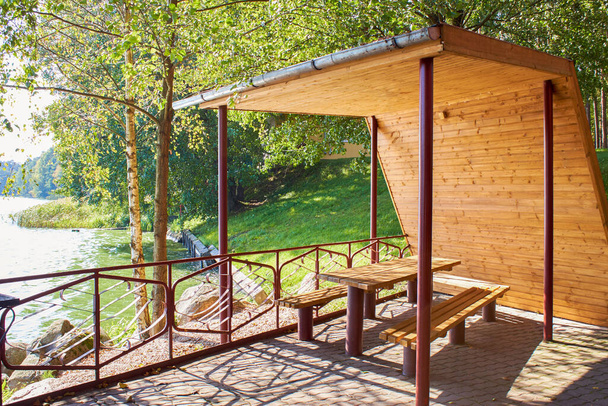 Gazebo de madera con un techo en la orilla del lago - Foto, imagen