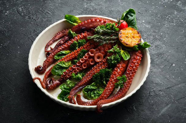 Baked octopus with spinach, lemon and parsley on a baking sheet. Top view. Flat lay. - Valokuva, kuva