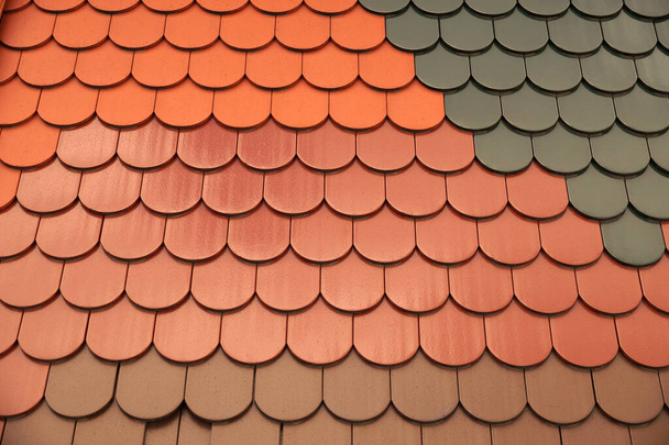 Roofing. Roof tiles of the same shape but differing in color and surface finish. - 写真・画像