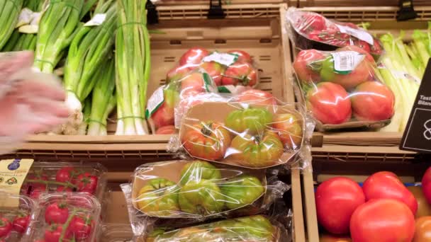 食料品店でトマトを摘む。スローモーションで市場でトマトを選ぶ手。スーパーマーケットでヘルシーな野菜. - 映像、動画