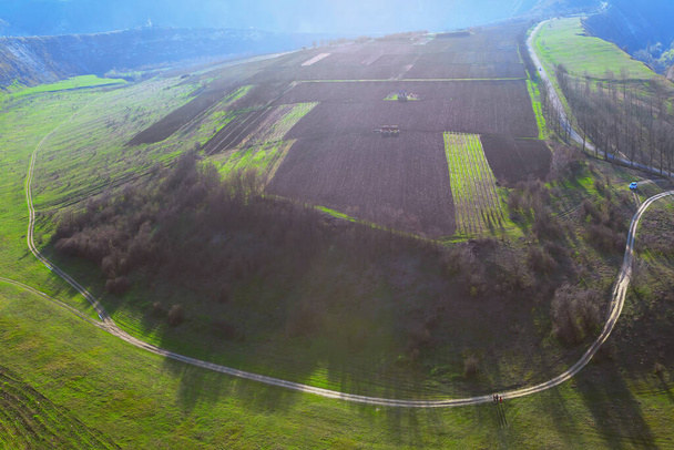 Luftaufnahme der Landstraße rund um landwirtschaftliche Felder. Panorama-Natur im Frühling  - Foto, Bild