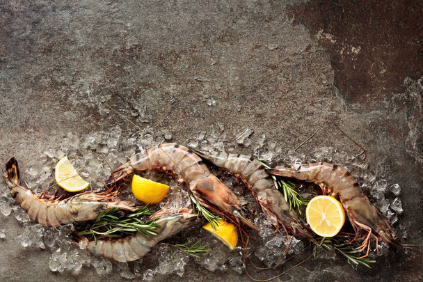 Fresh tiger prawns with lemon, rosemary and crushed ice, top view with copy space. - Photo, Image