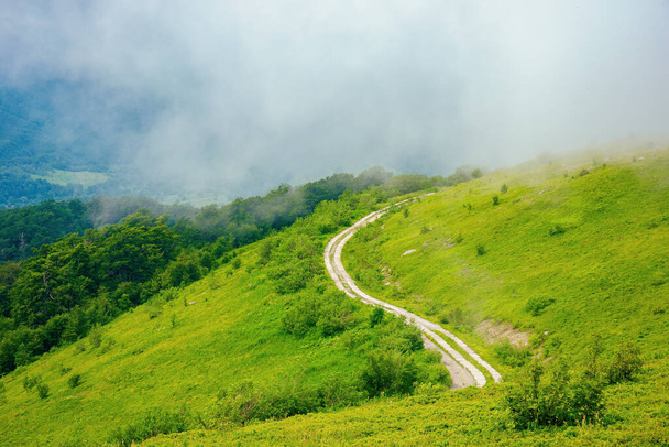road through mountain hills. beautiful summer landscape in the morning. clouds on the sky - Fotó, kép