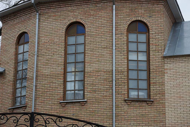 three big windows on a brown bricks wall of a building - Valokuva, kuva
