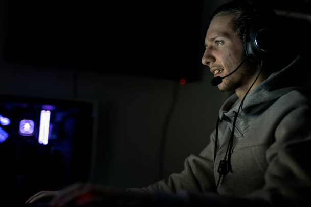 Jugador profesional o Streamer Juego de video en línea Shooter en primera persona en un PC de juego personalizado. Él está usando un auricular y está jugando en un teclado y el ratón - Foto, imagen