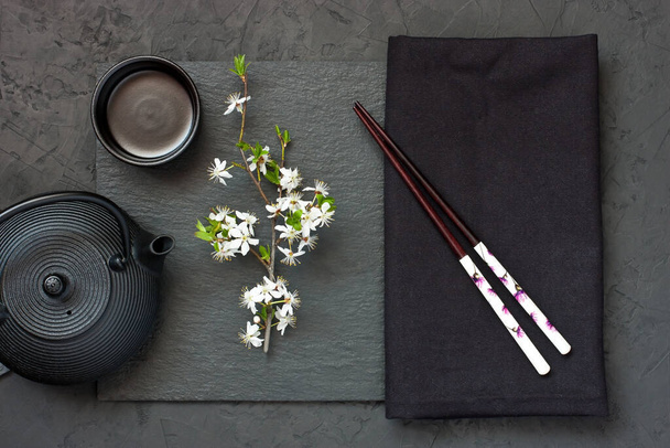 Asian tea bowl and teapot  on  dark stone table. Top view with copy space. Asian style composition  - Фото, зображення