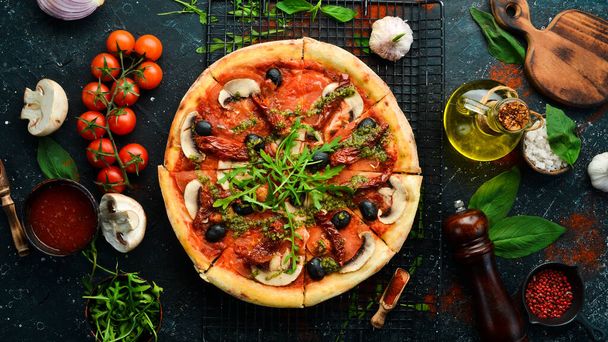 Homemade pizza with sun-dried tomatoes, mushrooms and olives. Italian cuisine. Food delivery. - Photo, image