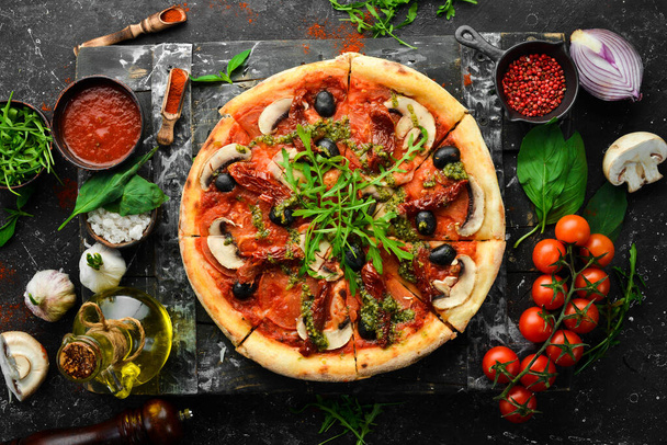 Domowej roboty pizza z suszonymi pomidorami, grzybami i oliwkami. Włoska kuchnia. Dostawa żywności. - Zdjęcie, obraz