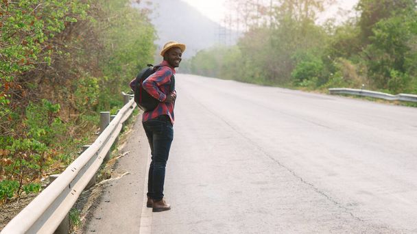 African man traveler  walking on the highway road with backpack - Foto, immagini