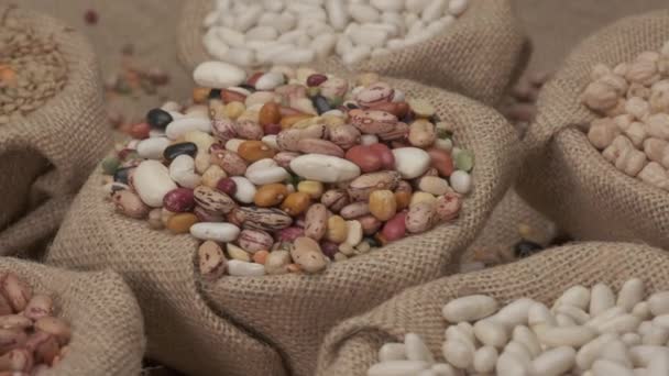 さまざまなマメ科の乾燥豆をジュートボウルに回転させます。典型的なビーガン食材,健康地中海料理 - 映像、動画