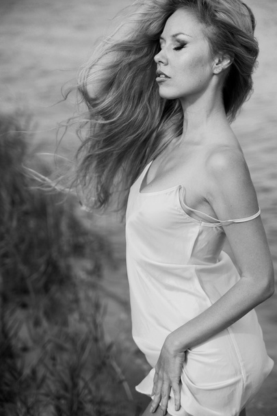 黒と白の写真の美しいですブロンド女性posingオンザビーチ  - 写真・画像
