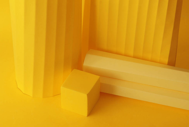Podium in gele kleur met geometrische vormen. Toneel met geometrische geometrische vormen van beton, gips. - Foto, afbeelding