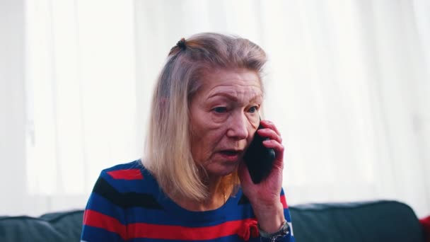 Desesperada mujer anciana preocupada teniendo una llamada telefónica - Imágenes, Vídeo