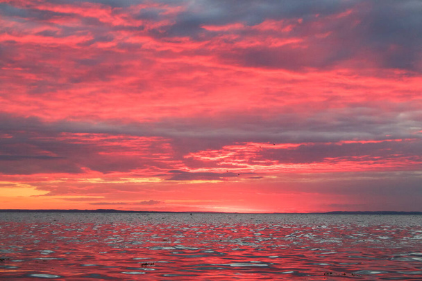 赤い雲と水で劇的な空 - 写真・画像