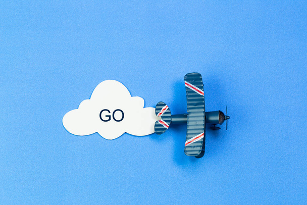 Toy airplane on a background of blue sky with paper cloud - Zdjęcie, obraz