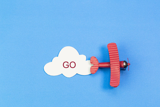 紙の雲と青空の背景におもちゃの飛行機 - 写真・画像