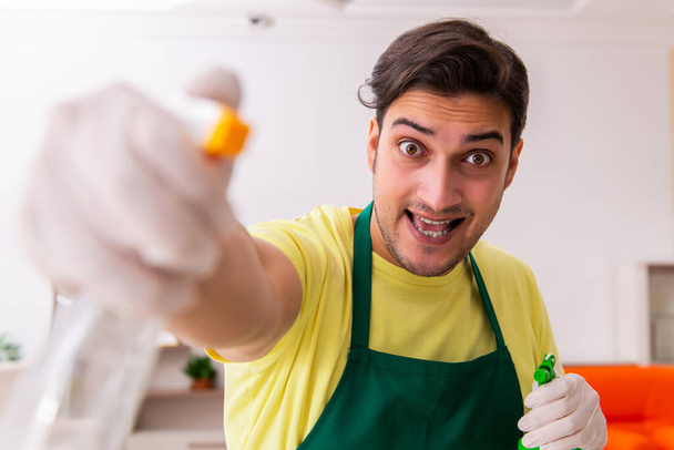 Jeune entrepreneur masculin nettoyer la maison à l'intérieur - Photo, image