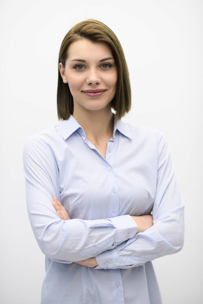 Portrati shot of beautiful blond businesswoman standing with arms crossed at isolated white background. - Foto, imagen