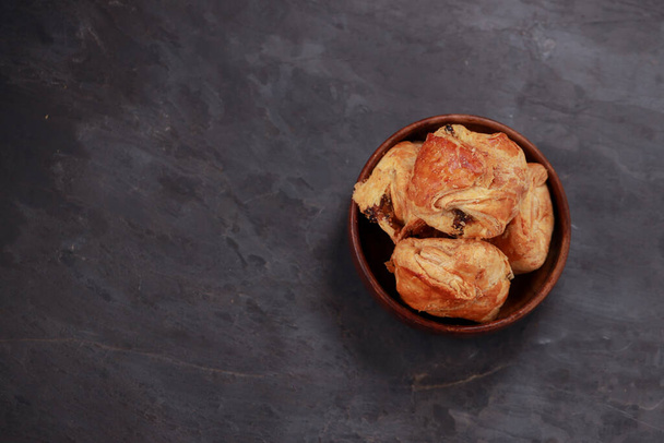 Muna Puff leivonnaiset täynnä mausteinen ja maukas muna masala ja sijoitetaan puinen pöytä ruokailuvälineet harmaa kuvioitu tausta, eristetty - Valokuva, kuva