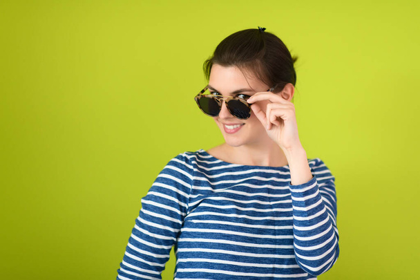woman in sunglasses posing in front of a green background - Foto, immagini