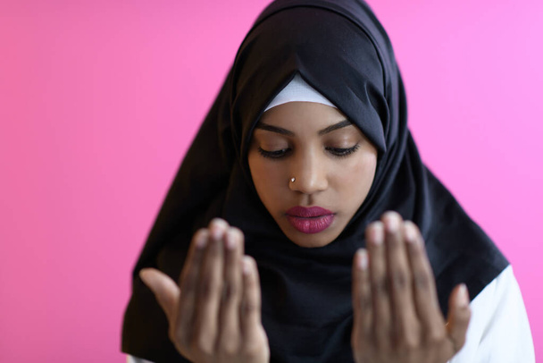 Modern African Muslim woman makes traditional prayer to God, keeps hands in praying gesture, wears traditional white clothes - Fotografie, Obrázek