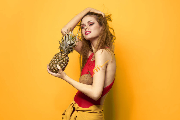 pretty woman with pineapple in her hands cosmetics exotic fruits yellow background fun - Zdjęcie, obraz