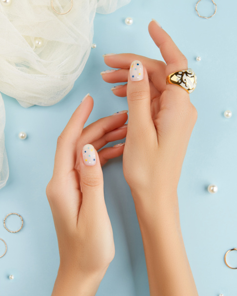 Hermosas manos de mujer arreglada con diseño de uñas de verano sobre fondo azul - Foto, imagen