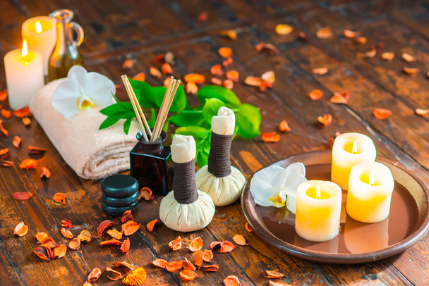 Spa background. Towel, candles, flowers, aroma sticks, massaging stones and herbal balls. Massage, oriental therapy, wellbeing and meditation. - Photo, Image