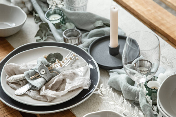 Detailaufnahme einer festlichen Tischdekoration mit Besteck, Teller und Kerzen im Kerzenständer. - Foto, Bild